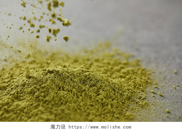 桌子上的抹茶粉末绿色火柴粉末浇注在桌子上的选择性焦点